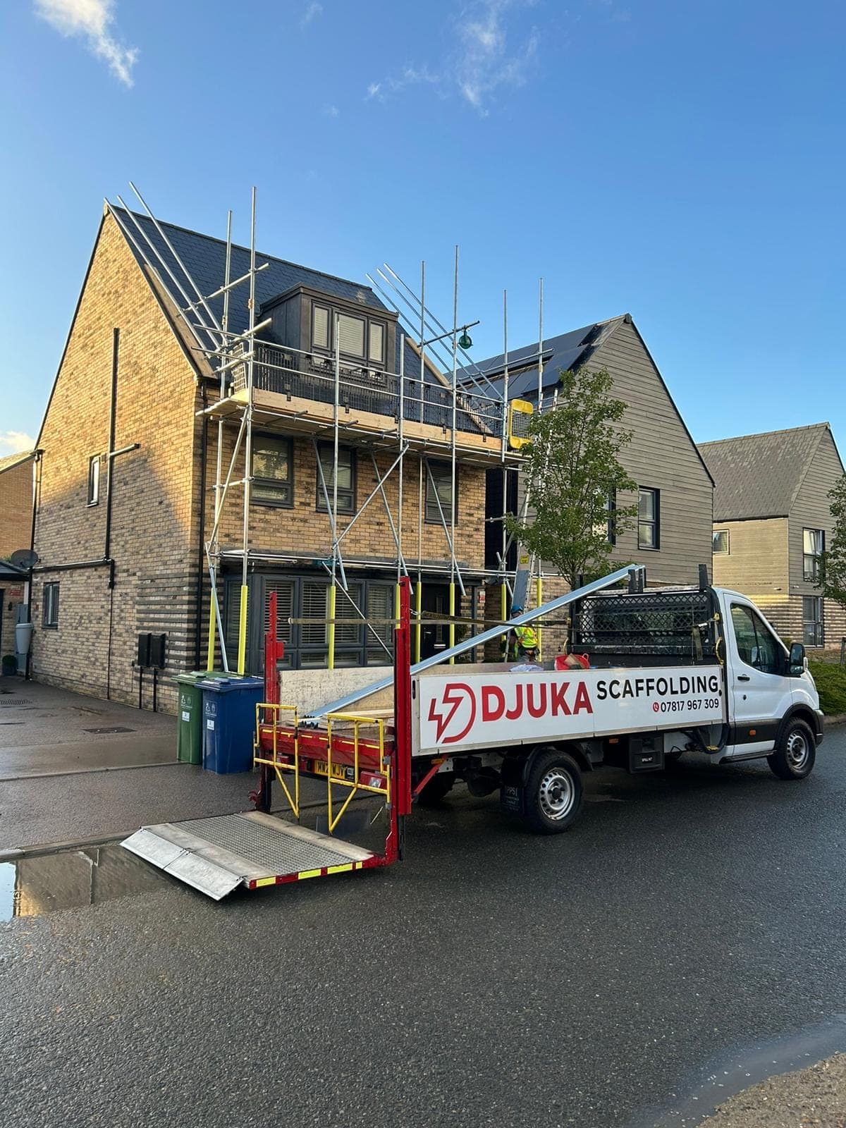 Djuka Scaffolding truck on-site at a modern home with scaffolding erected
