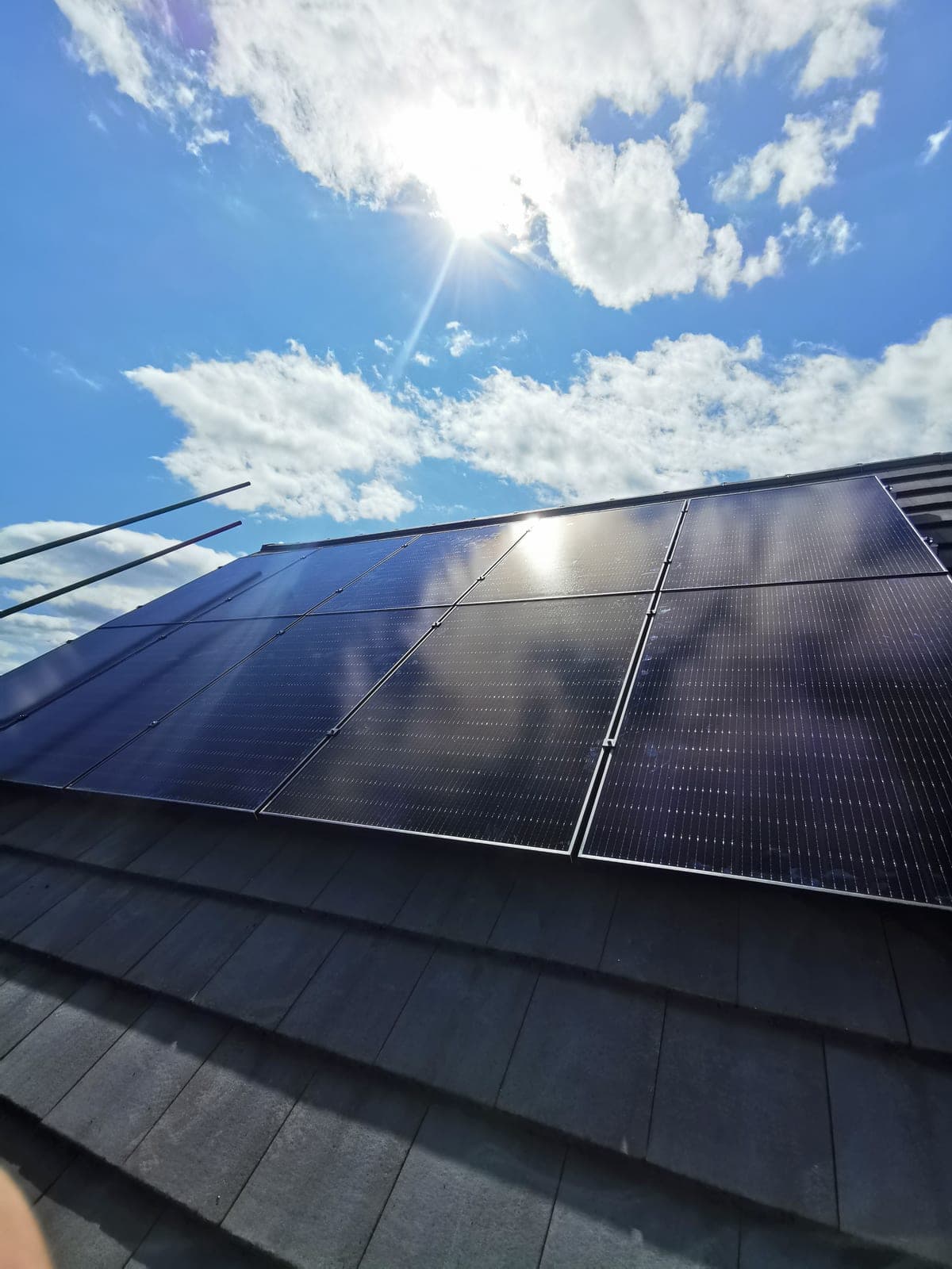 Solar panels close-up with sun flare against a blue sky
